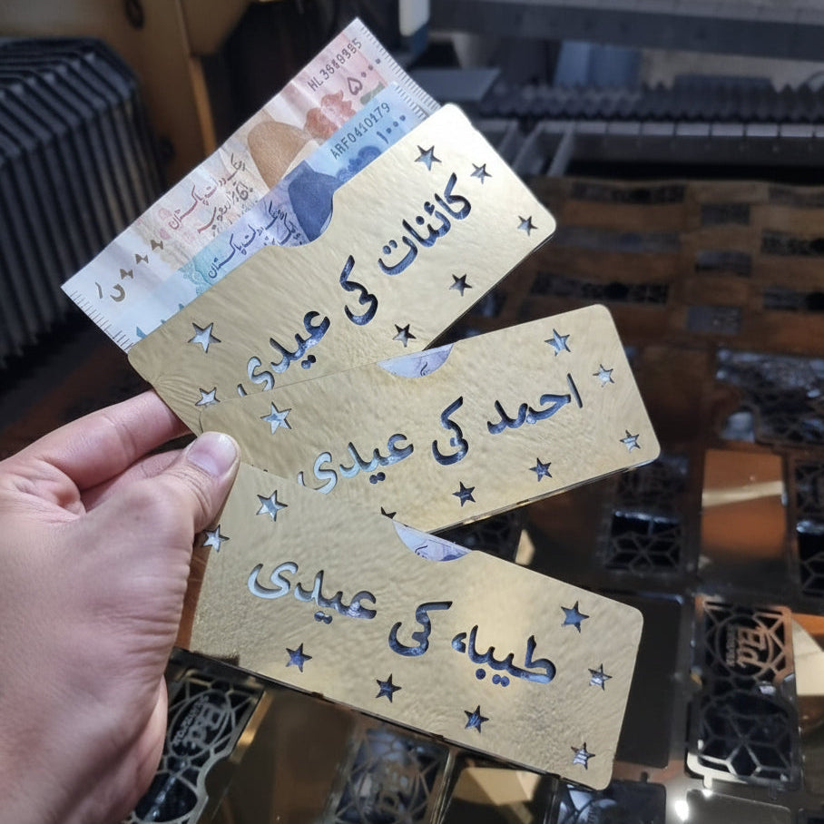 Hand holding a wooden named Envelope with Arabic text against a blurred background